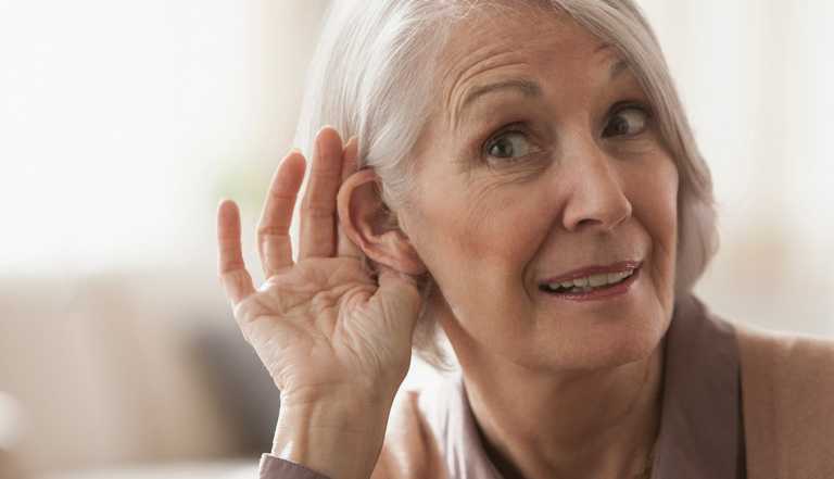 Woman cupping her ear to listen